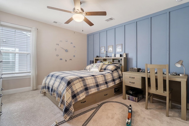 bedroom featuring ceiling fan, multiple windows, and light colored carpet