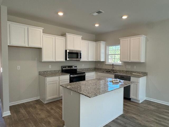 kitchen featuring white cabinets, a center island, sink, and stainless steel appliances