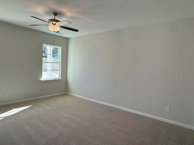 empty room featuring carpet flooring and ceiling fan