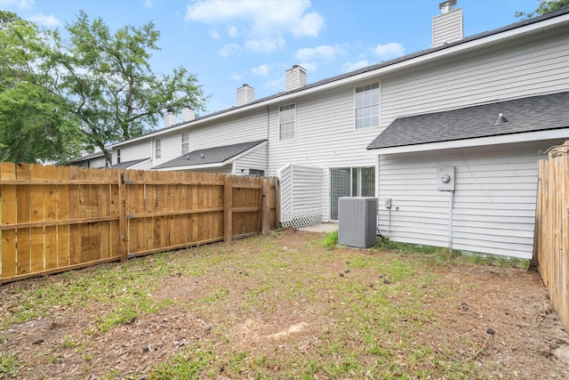 7813 Sandida Ct, North Charleston, SC 29418 - rear view of house featuring a chimney, central AC unit, and roof with shingles