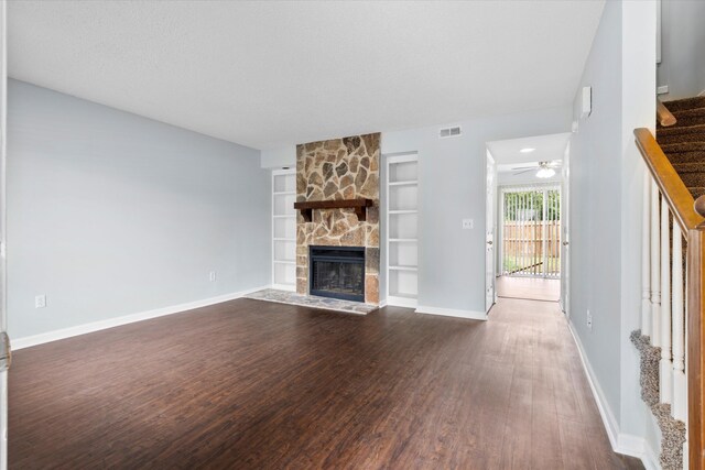 7813 Sandida Ct, North Charleston, SC 29418 - unfurnished living room featuring stairway, dark wood-style floors, a stone fireplace, built in features, and baseboards