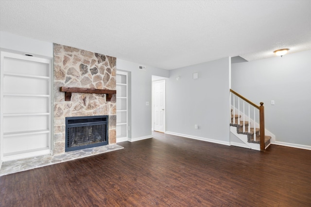 7813 Sandida Ct, North Charleston, SC 29418 - unfurnished living room featuring built in shelves, baseboards, a textured ceiling, stairs, and wood finished floors