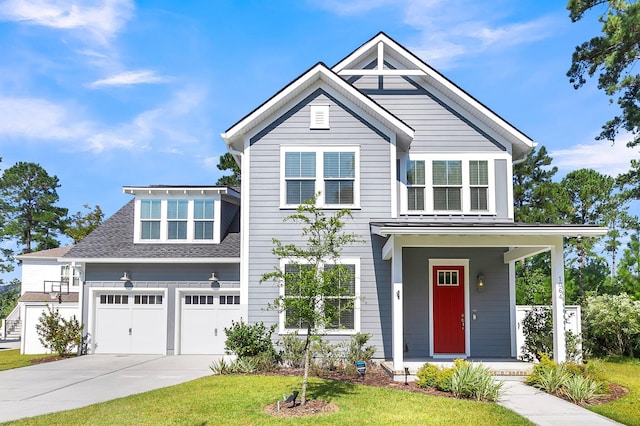 view of front of house featuring a garage, a front lawn, and a porch