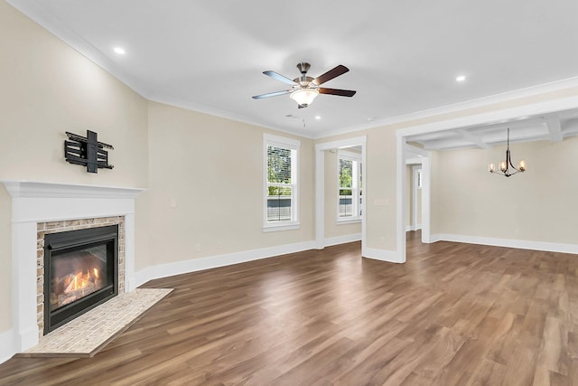 unfurnished living room featuring beamed ceiling, ornamental molding, dark wood-type flooring, and ceiling fan with notable chandelier