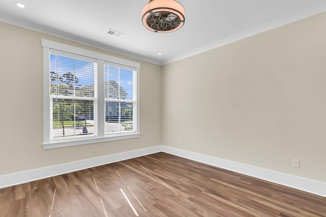 spare room featuring hardwood / wood-style floors and crown molding