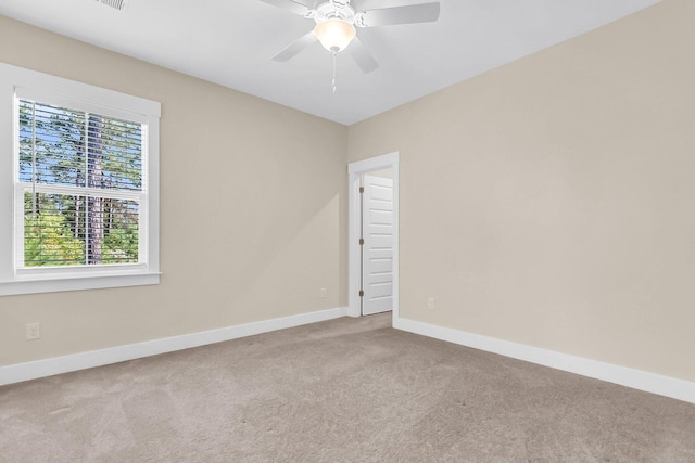 carpeted spare room featuring ceiling fan