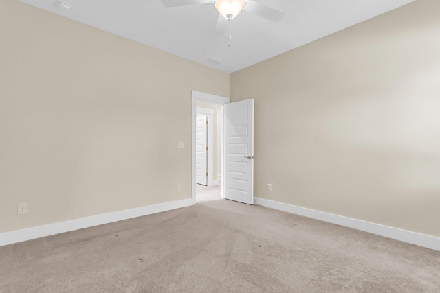 carpeted spare room featuring ceiling fan