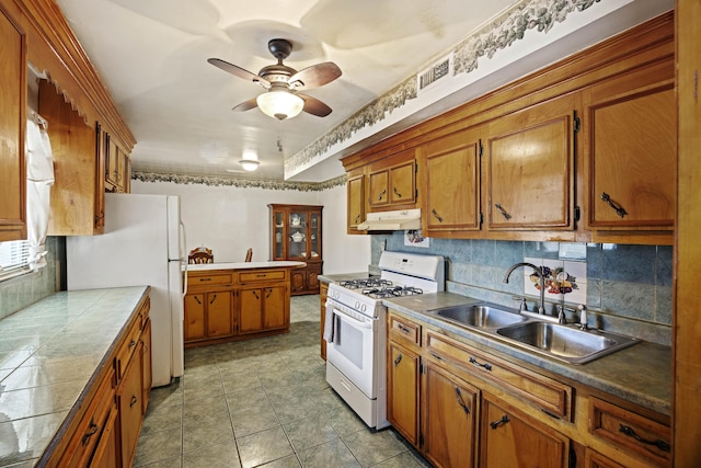 kitchen featuring white appliances, light tile patterned floors, ceiling fan, decorative backsplash, and sink