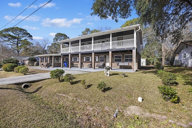 back of house featuring a balcony, a patio area, and a lawn