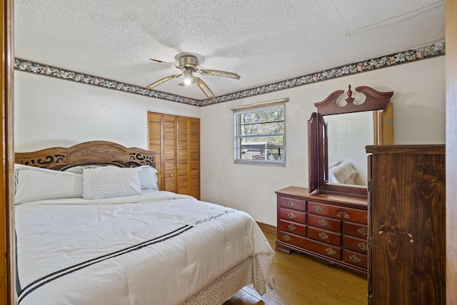 bedroom featuring a textured ceiling, ceiling fan, a closet, and hardwood / wood-style floors