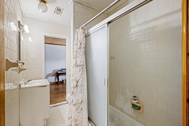 bathroom featuring tile walls, tile patterned flooring, ornamental molding, and vanity