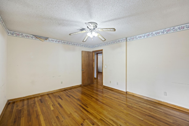 empty room with a textured ceiling, ceiling fan, and hardwood / wood-style floors