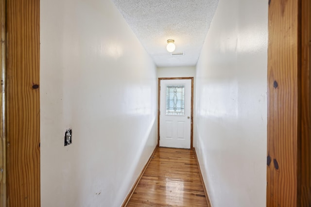 entryway featuring a textured ceiling and light hardwood / wood-style flooring