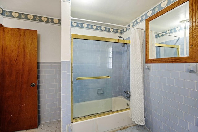 bathroom with tile walls, tile patterned flooring, and bath / shower combo with glass door