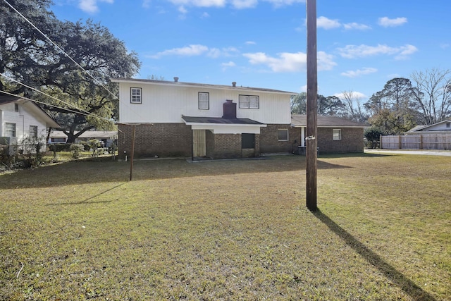 rear view of house featuring a yard