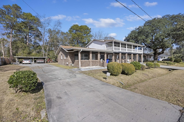 view of front facade with a porch, a front yard, and a carport