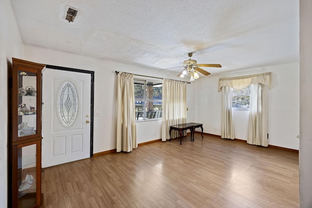 foyer featuring a textured ceiling, ceiling fan, and light hardwood / wood-style flooring