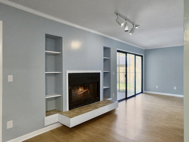10 Stallion Ct, Charleston, SC 29407 - unfurnished living room with built in shelves, a warm lit fireplace, wood finished floors, ornamental molding, and track lighting