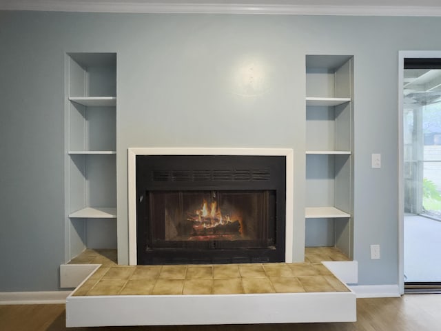 10 Stallion Ct, Charleston, SC 29407 - detailed view of built in shelves, a lit fireplace, crown molding, and wood finished floors