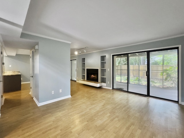 10 Stallion Ct, Charleston, SC 29407 - unfurnished living room featuring built in features, wood finished floors, ornamental molding, and a warm lit fireplace