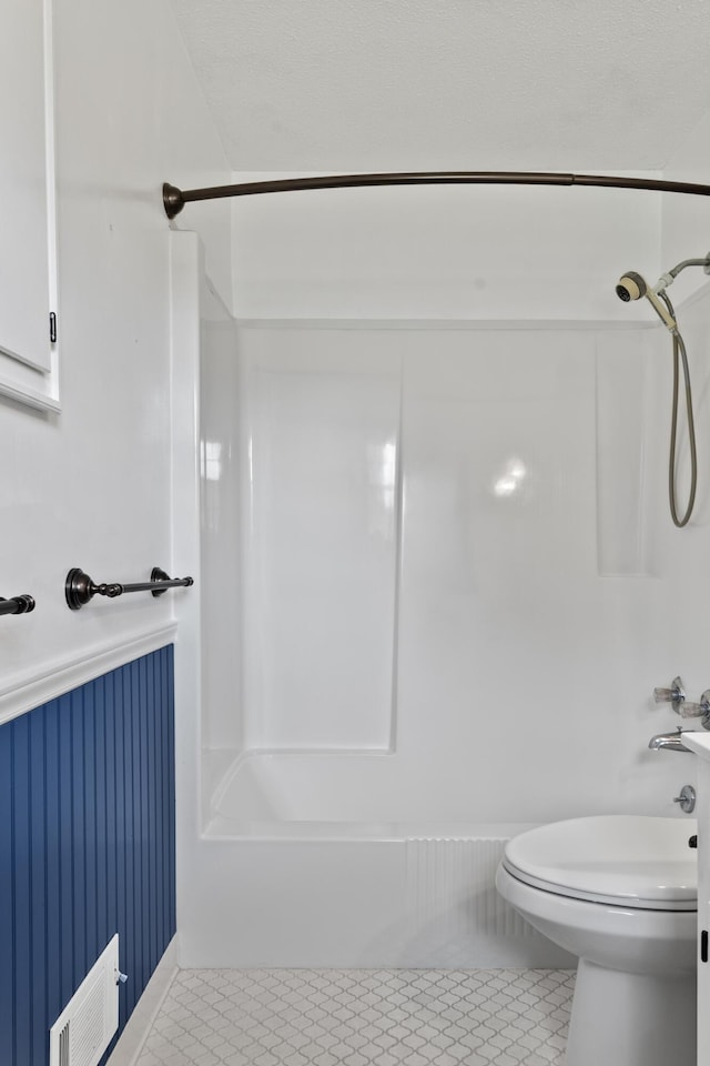 4097 NE Brown St, Orangeburg, SC 29118 - full bathroom featuring tub / shower combination, wainscoting, tile patterned floors, and toilet