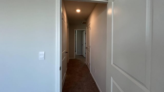 hallway featuring dark colored carpet