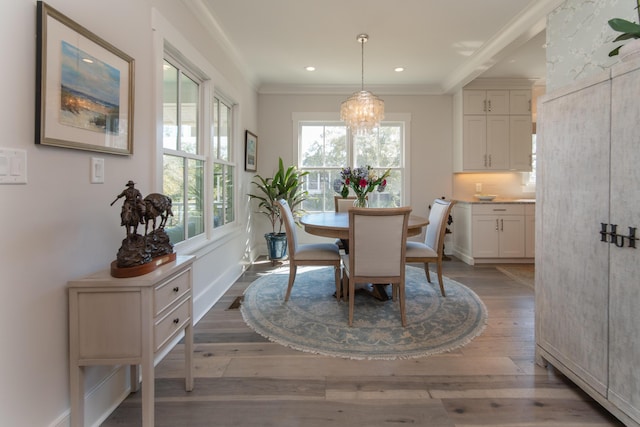 dining space with dark wood-style flooring, recessed lighting, ornamental molding, a chandelier, and baseboards