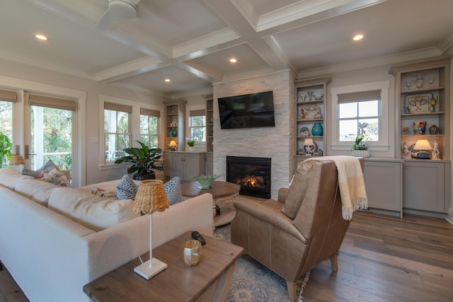 living room featuring plenty of natural light, a fireplace, dark wood finished floors, and beamed ceiling