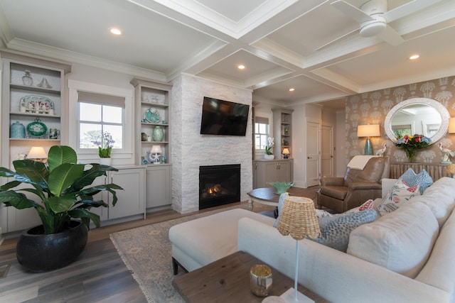 living area with dark wood-style floors, coffered ceiling, beamed ceiling, and a stone fireplace