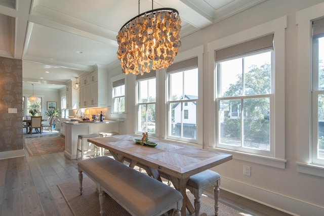 dining area with baseboards, wood finished floors, beam ceiling, and a notable chandelier