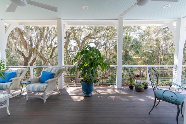 unfurnished sunroom with a ceiling fan and a healthy amount of sunlight