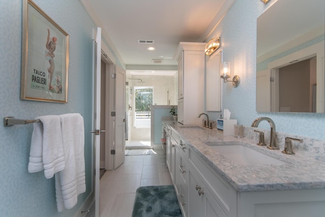 bathroom featuring double vanity, visible vents, a sink, and tile patterned floors