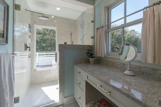 bathroom featuring a healthy amount of sunlight, a shower stall, and vanity