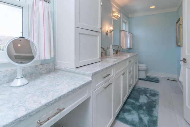 full bathroom with double vanity, tile patterned flooring, a sink, and baseboards