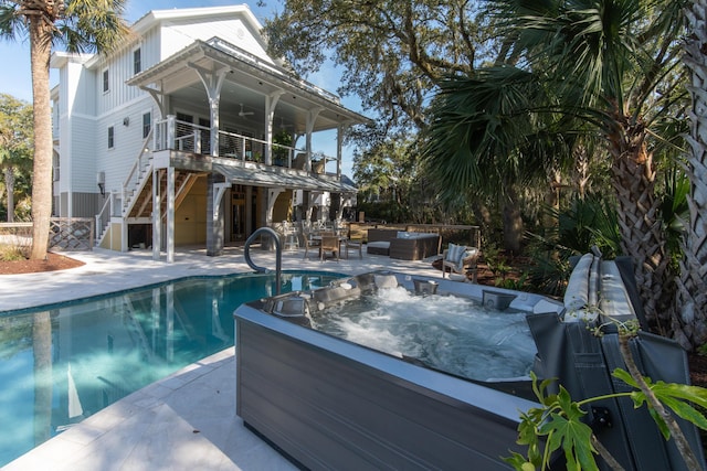 view of swimming pool featuring outdoor lounge area, a patio area, stairs, and an outdoor hot tub