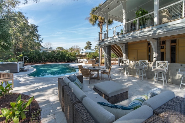 outdoor pool with an outdoor living space, a jacuzzi, outdoor dry bar, and a patio