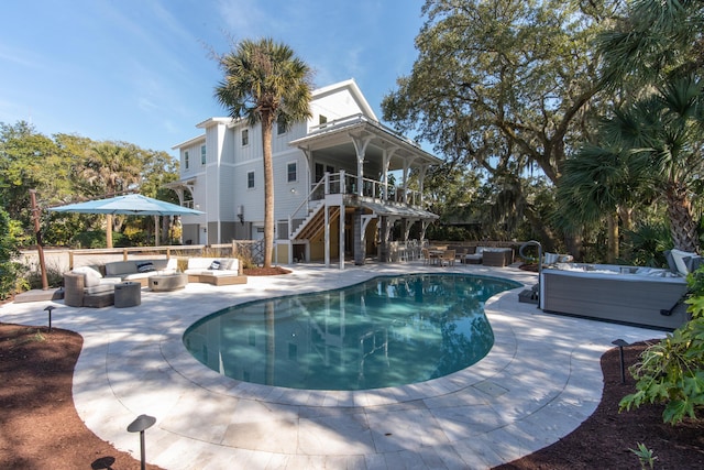 view of pool featuring an outdoor hangout area, stairway, a fenced in pool, a patio area, and a hot tub