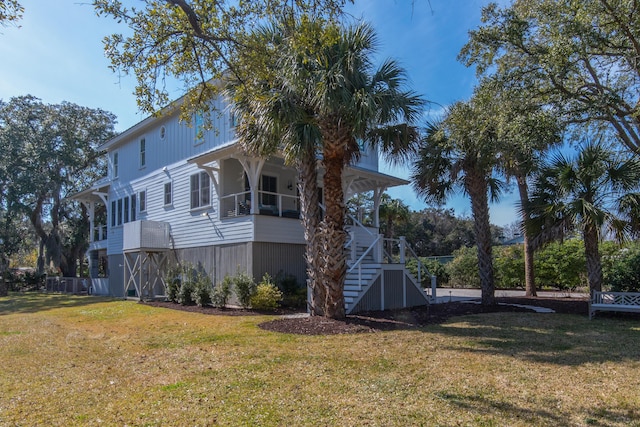 view of side of home with a yard and stairway