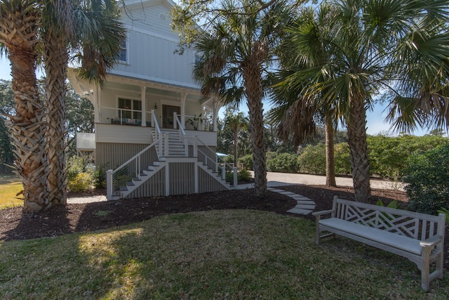 view of yard featuring stairs and covered porch