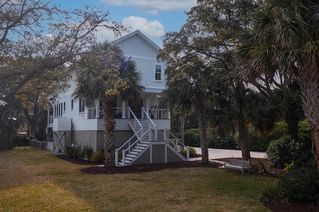 view of front of house with covered porch, stairway, and a front yard