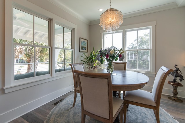 dining room featuring dark wood-style floors, baseboards, ornamental molding, and a chandelier