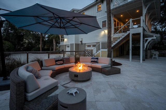 view of patio with stairway and an outdoor living space with a fire pit