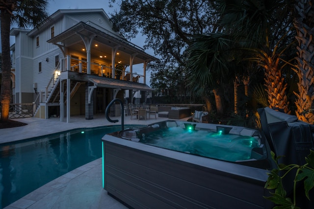 view of pool with an outdoor hot tub, a patio, and stairs