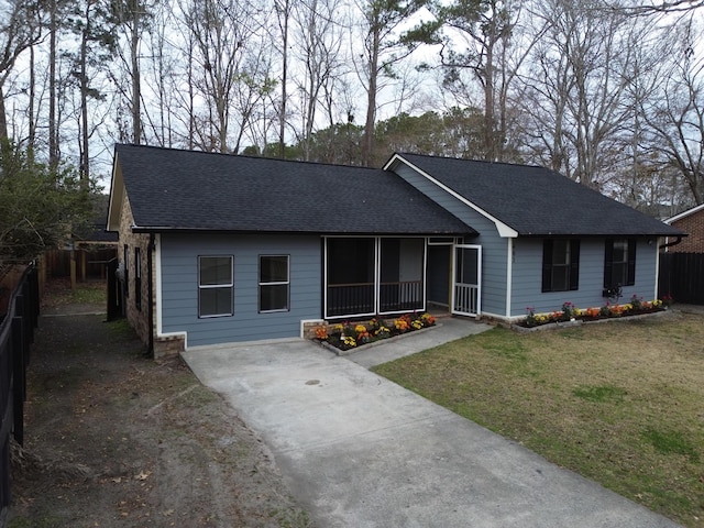 ranch-style house featuring covered porch and a front lawn