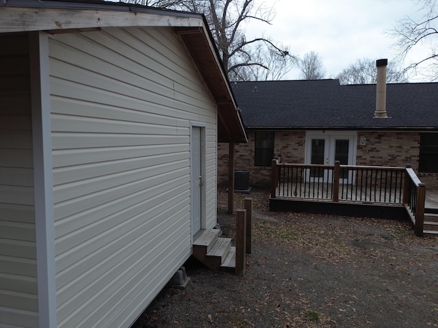 view of side of home with central AC unit, french doors, and a deck