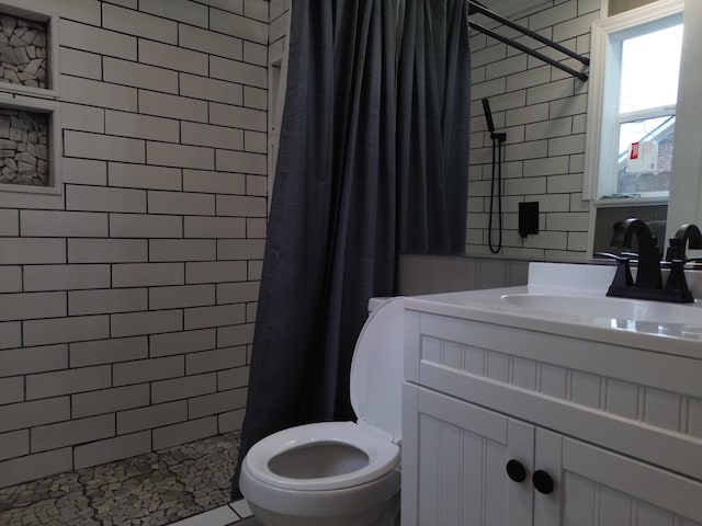 bathroom featuring walk in shower, vanity, and toilet