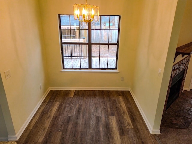 unfurnished dining area with dark hardwood / wood-style flooring and a chandelier