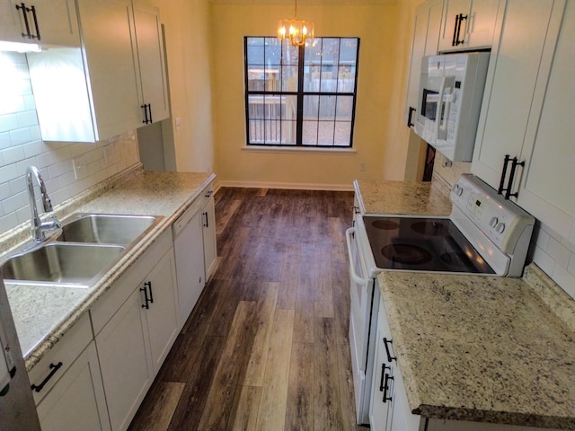 kitchen with white cabinetry, sink, dark hardwood / wood-style flooring, hanging light fixtures, and white appliances