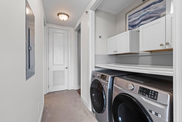 laundry area featuring baseboards, washer and clothes dryer, cabinet space, and light carpet