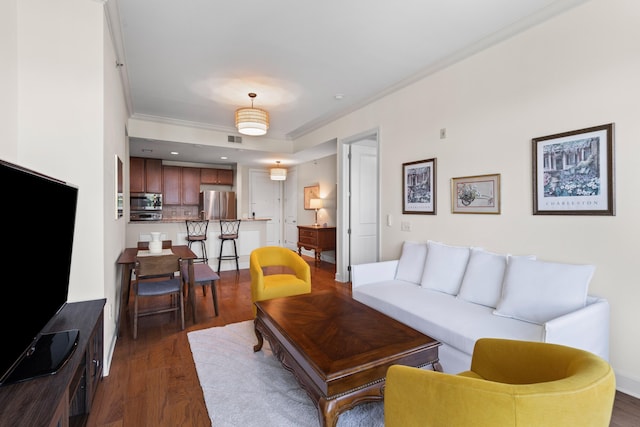 living area featuring dark wood-style flooring, visible vents, and ornamental molding
